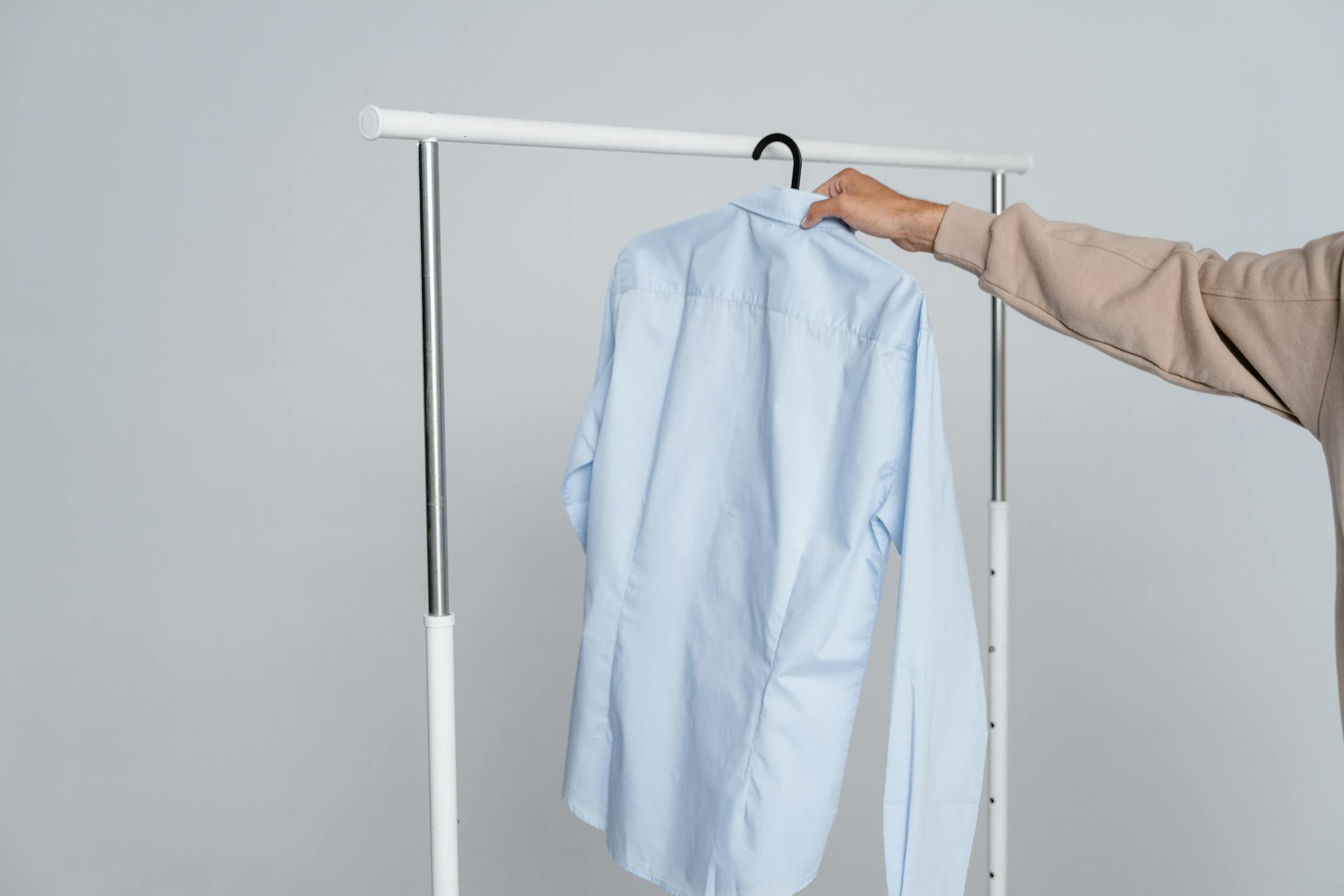 Freshly cleaned blue dress shirt hanging on a clothing rack